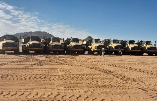 Dump truck fleet lined up in the desert